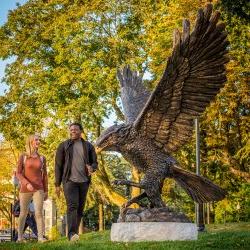 Montclair State Students walk past the Red Hawk statue